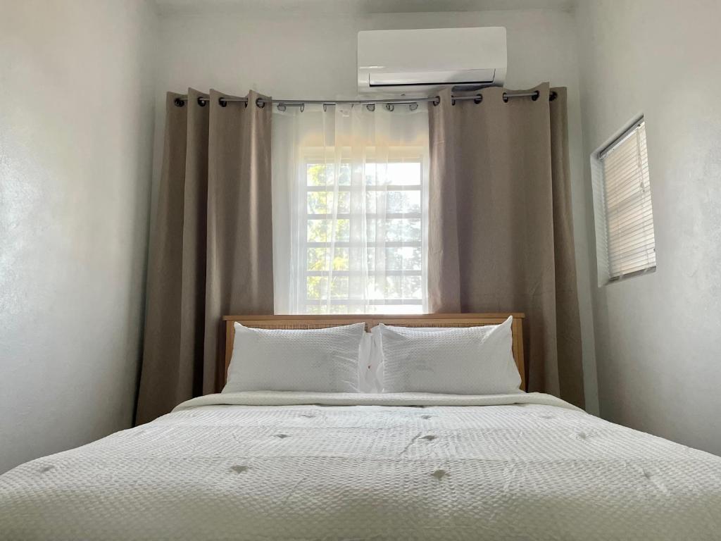 ein Bett mit weißer Bettwäsche und einem Fenster in der Unterkunft Abigail's Sunlit Nook in Tortola Island