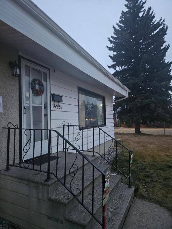 Ein Haus mit einer Veranda und einem Kranz an der Tür in der Unterkunft P&N Suites - DELUXE QUEEN ROOM- LONDON in Edmonton