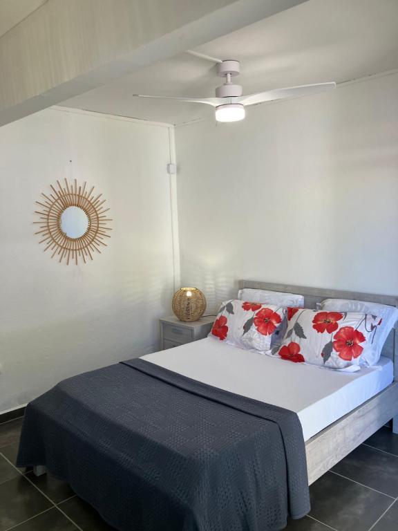 ein Schlafzimmer mit einem Bett und einem Deckenventilator in der Unterkunft Tilys lodge in Capesterre-Belle-Eau