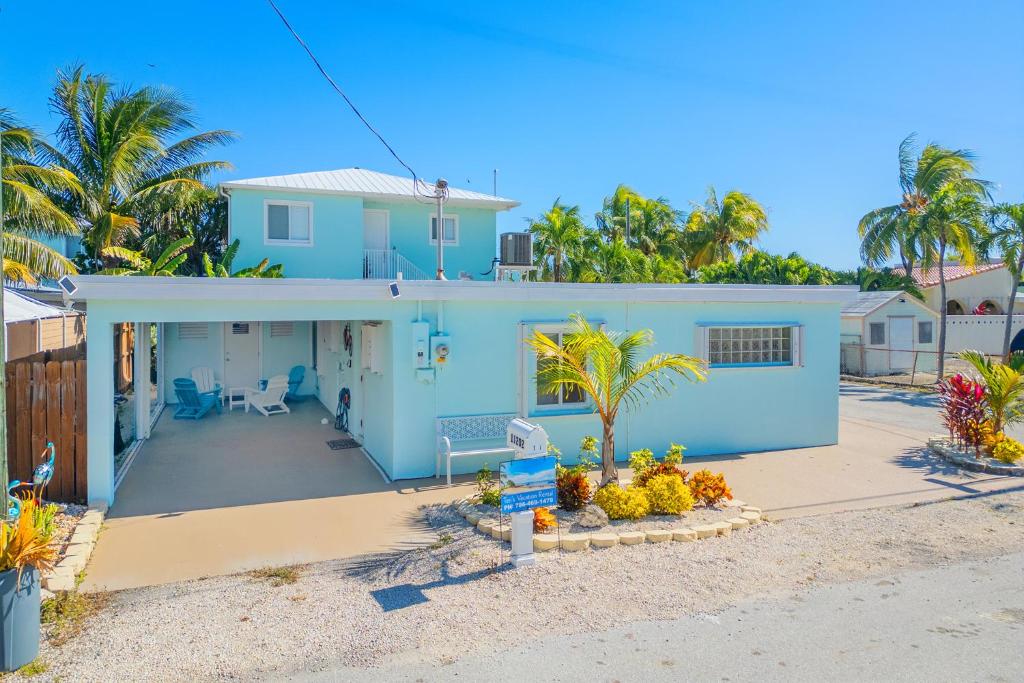 una casa blu sulla spiaggia con palme di Vacation Rental Florida Keys a Marathon