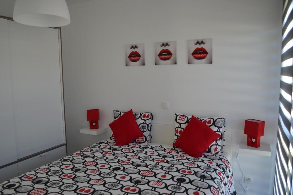 een slaapkamer met een bed met rode kussens bij La boîte rouge in Stavelot