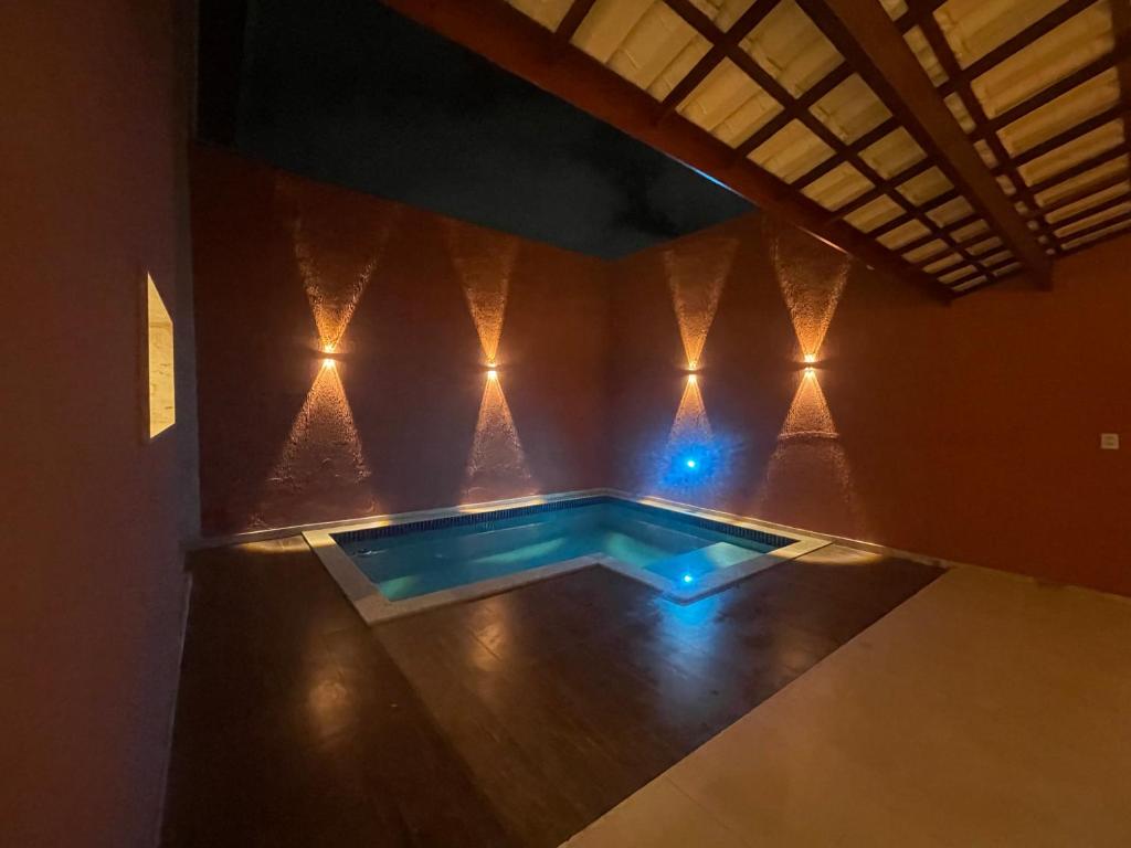 ein Swimmingpool in der Mitte eines Raumes mit Lichtern in der Unterkunft Village GRAND LUX exclusivo com piscina privativa in Feira de Santana