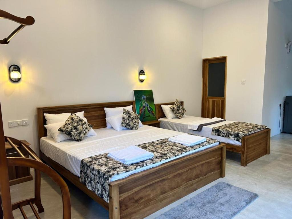 ein Schlafzimmer mit 2 Betten und einem Stuhl darin in der Unterkunft Villa Tesh Hiriketiya in Dikwella