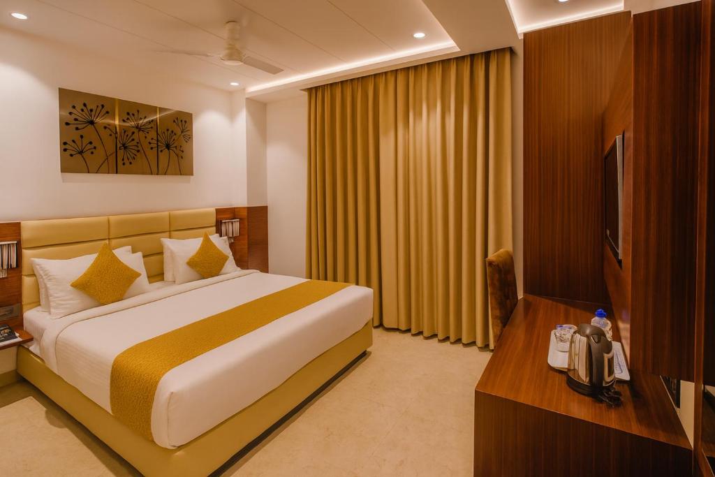 a hotel room with a bed and a television at HOTEL TEN SQUARE - 5 Minutes from The Taj Mahal in Agra