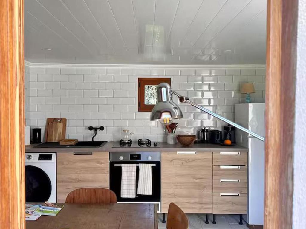 a kitchen with a stove and a lamp in it at Gîte de charme calme au cœur du Perche, proche Le Mans - FR-1-410-478 in Courgains