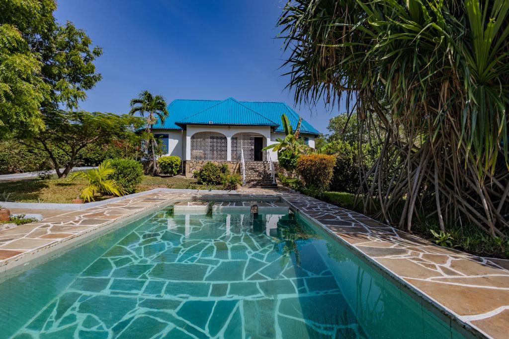 an image of a swimming pool in front of a house at Auregi Villas - 2 and 3 bedroom near Diani Beach in Diani Beach