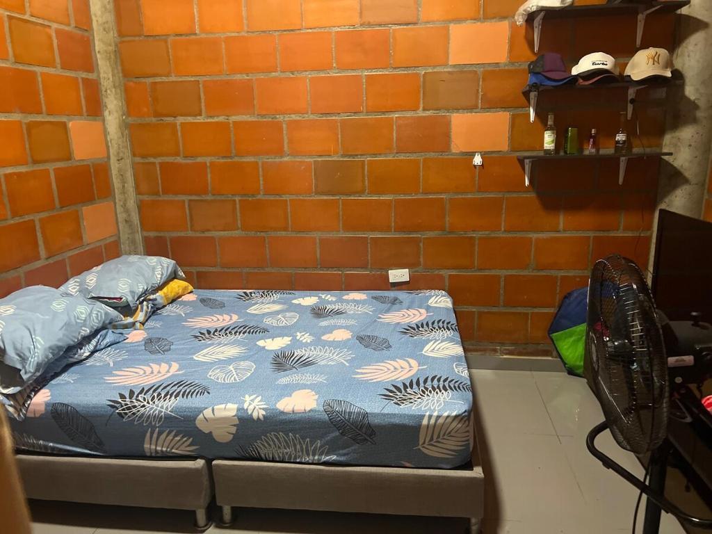 a bed in a room next to a brick wall at Villa Lolita in Palmaseca