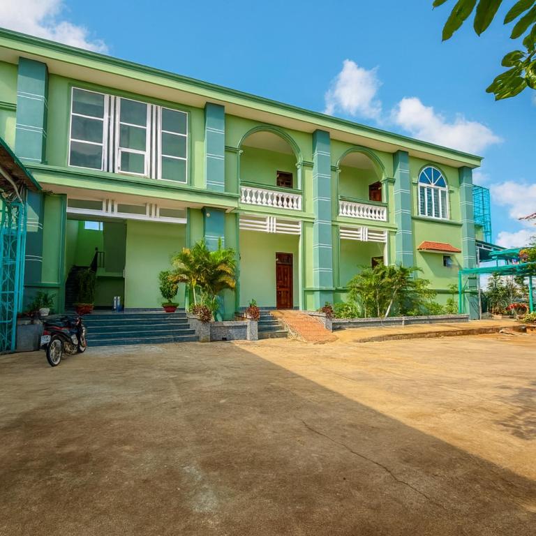 a green house with a driveway in front of it at Hồng Ngọc 2 Hotel Tà Đùng in Biđong