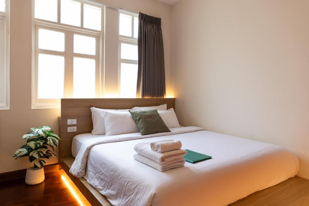 a bedroom with a bed with towels on it at Belivin99 Residence Chinatown in Bangkok