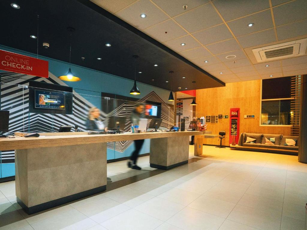 eine Person, die an einer Theke in einem Fast-Food-Restaurant vorbeigeht in der Unterkunft Ibis Budget São Bernardo do Campo in São Bernardo do Campo