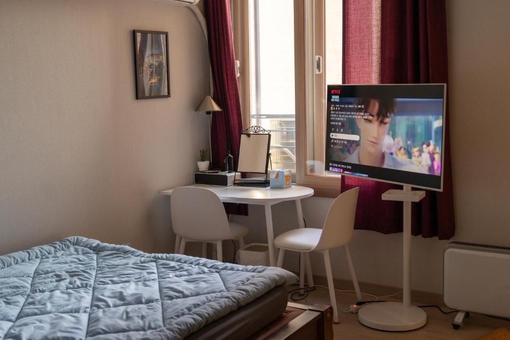Un dormitorio con una cama, una mesa y un televisor. en Josh's Homestay, 