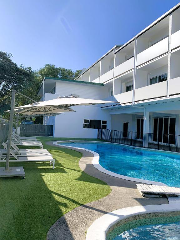 a house with a swimming pool and a building at Mercure Tauranga in Tauranga