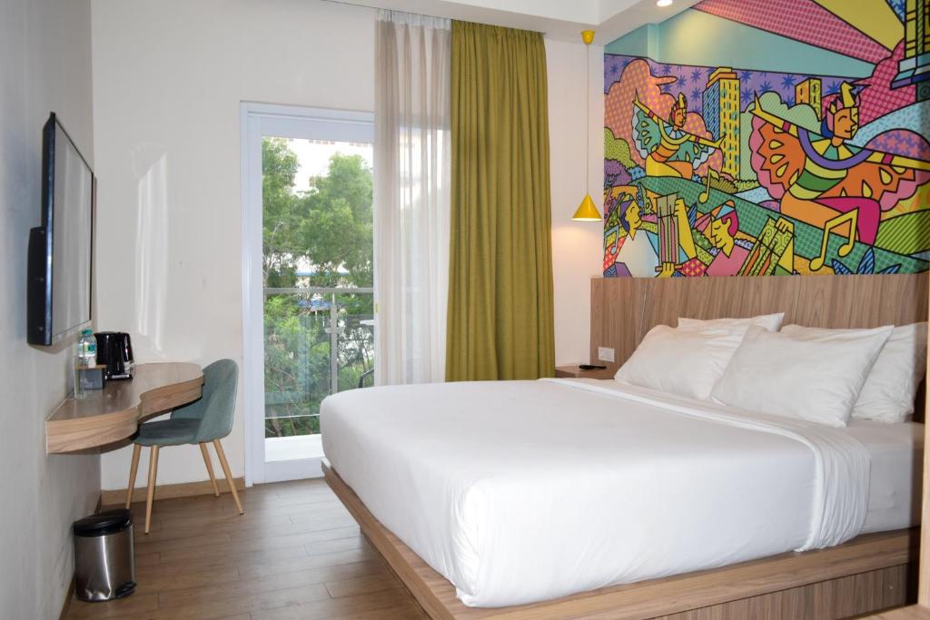 une chambre avec un lit et un tableau au mur dans l'établissement MaxOneHotels at Kota Harapan Indah-Bekasi, à Bekasi