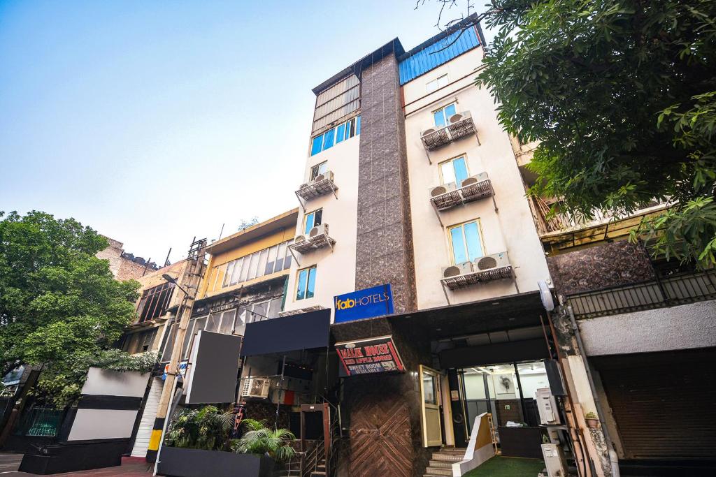 ein hohes weißes Gebäude auf einer Stadtstraße in der Unterkunft FabHotel Red Apple in Neu-Delhi