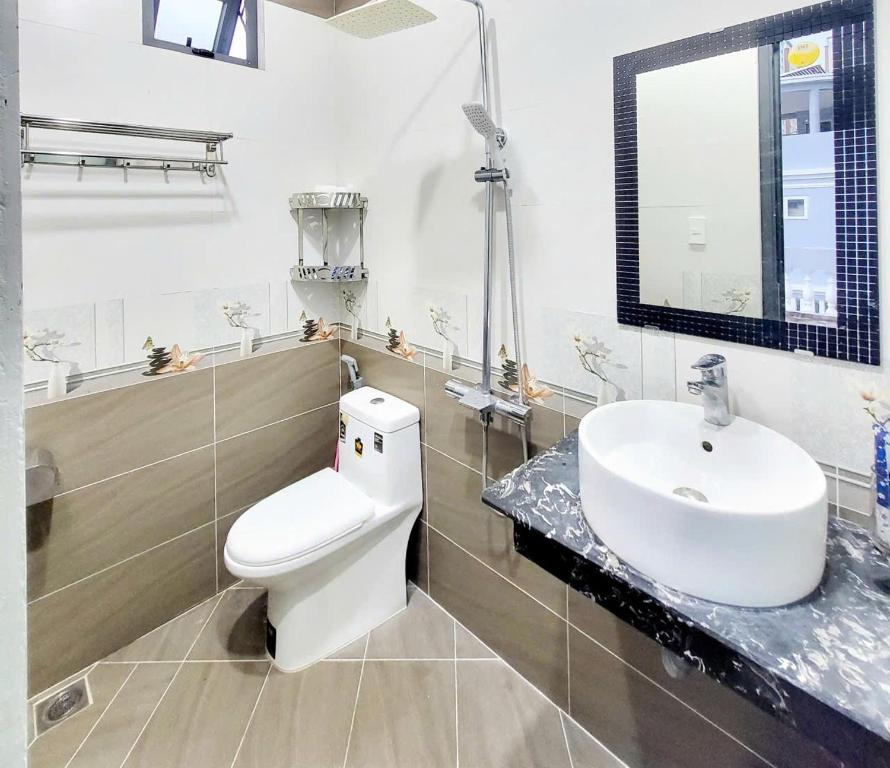 a bathroom with a white toilet and a sink at HA Hotel & Apartment in Vung Tau