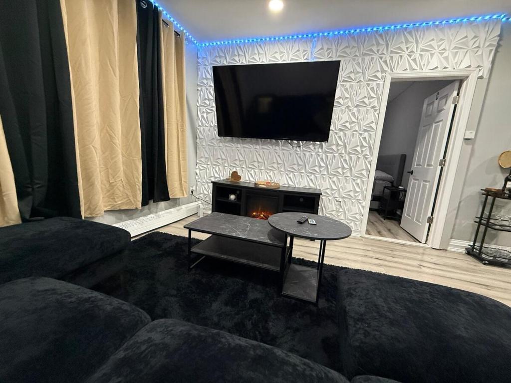 伊丽莎白Huge Elegant condo near EWR and NYC and NJ Transit Unit 1的客厅里有一张沙发，墙上有一台电视