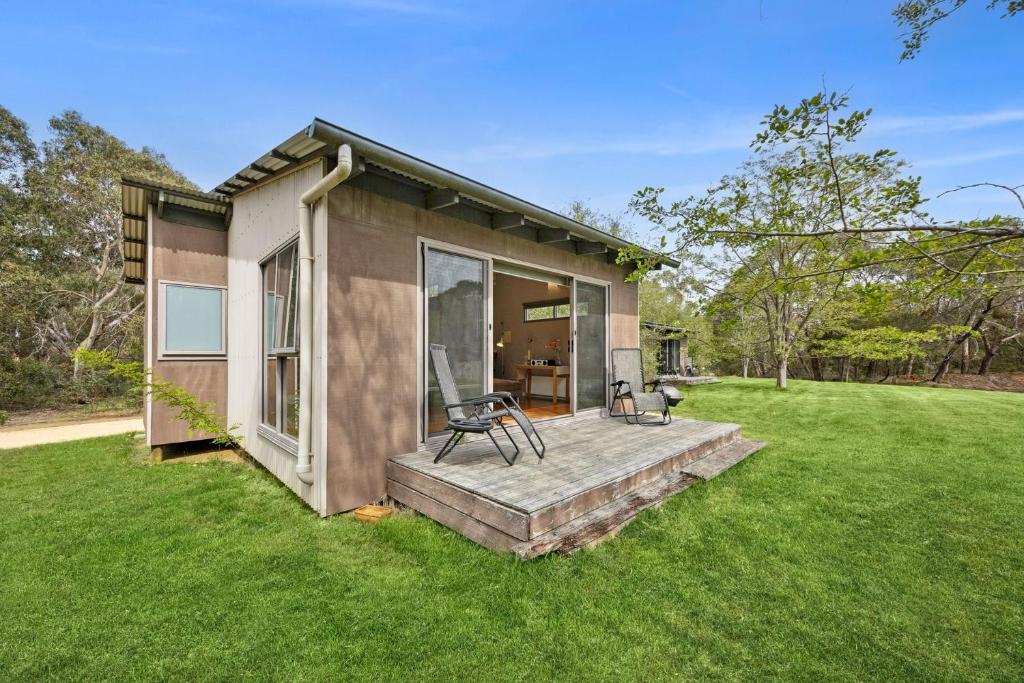 a small house with a porch and a lawn at Bellbrae Harvest in Torquay