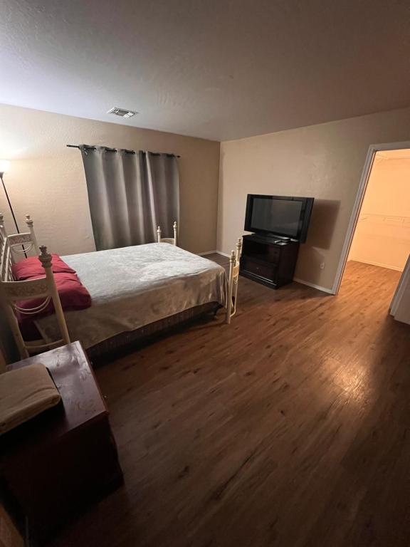 Un dormitorio con una cama y un televisor de pantalla plana. en West Phoenix Value Room 5, en Phoenix