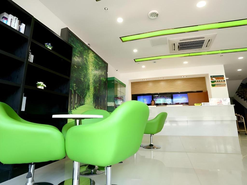 a green restaurant with a table and green chairs at Vatica JiangsuJianguo Road Xuanwu Market Hotel in Xuzhou