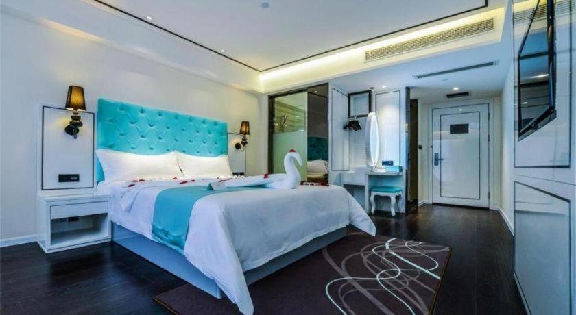 a bedroom with a large bed with a blue headboard at Xana Lite Yichun Fengcheng Municipal Government Branch in Sunjiadu