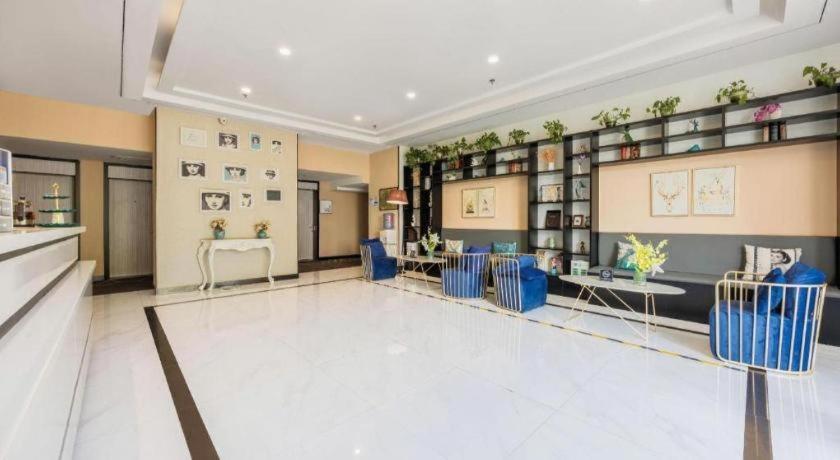 a large room with blue chairs and tables in it at Xana Lite Beijing Liangxiang University City Branch in Wangzhuang