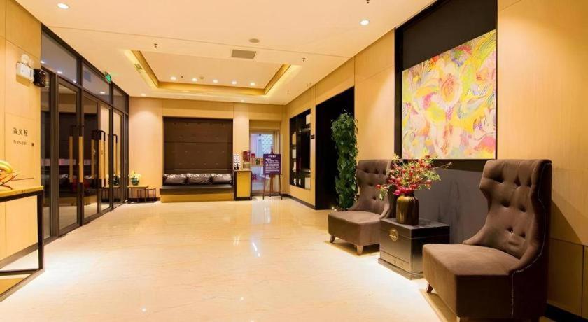 eine Lobby mit zwei Stühlen und einem Gemälde an der Wand in der Unterkunft Yitel Shenyang Sanhao Street Shengjing Hospital in Shenyang