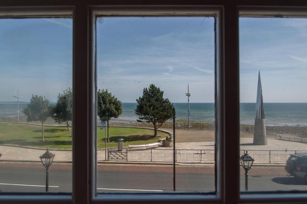 a window with a view of the beach and the ocean at The Haven in Newcastle