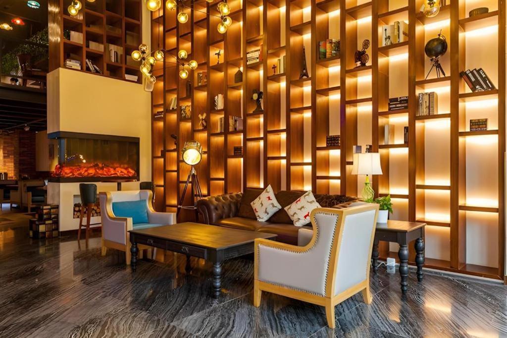 eine Lobby mit einem Sofa und einem Tisch und Stühlen in der Unterkunft James Joyce Coffetel Chengdu Century City Convention and Exhibition Center in Chengdu