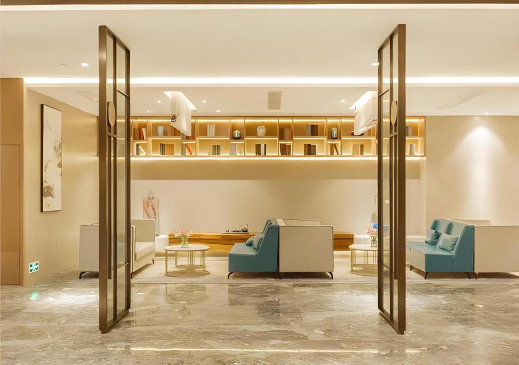 a lobby with two blue chairs and a table at Borrman Hotel Liuzhou Guizhong Avenue Liugao in Liuzhou