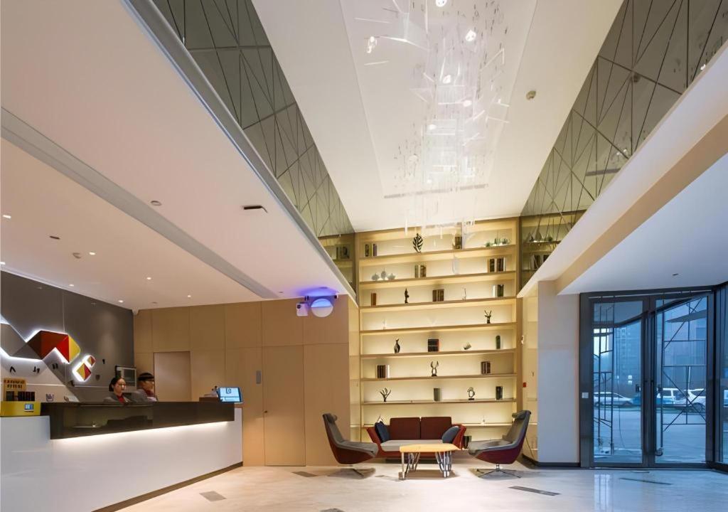 a lobby with a table and chairs in a building at Borrman Hotel Qianjiang High-speed Railway Station Lobster City in Sanjiang