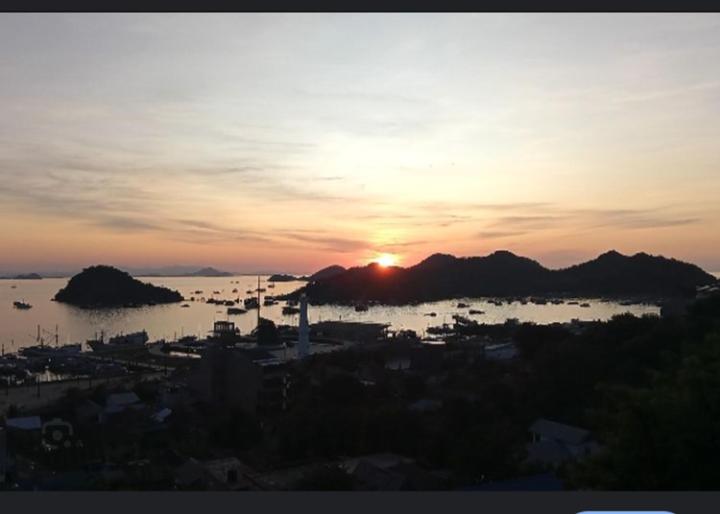 ein Sonnenuntergang über einer Stadt und einem Gewässer in der Unterkunft Lenarda hotel in Nggorang