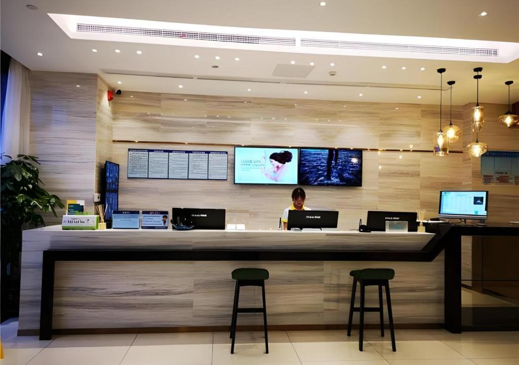 a woman sitting at a counter in a restaurant at City Comfort Inn Mianyang Southwest University Of Science And Technology in Qinglianchang