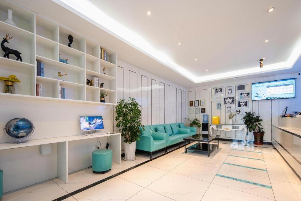 a living room with a blue couch and shelves at Xana Lite· Xi'an South Gate Yongningmen Subway Station in Xi'an