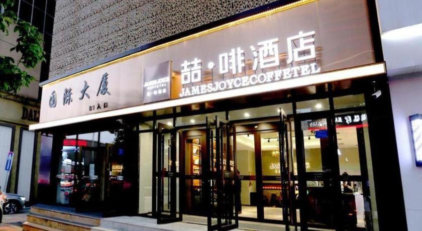 einen Laden vor einem Gebäude mit Schildern in der Unterkunft James Joyce Coffetel Changchun People's Square in Changchun