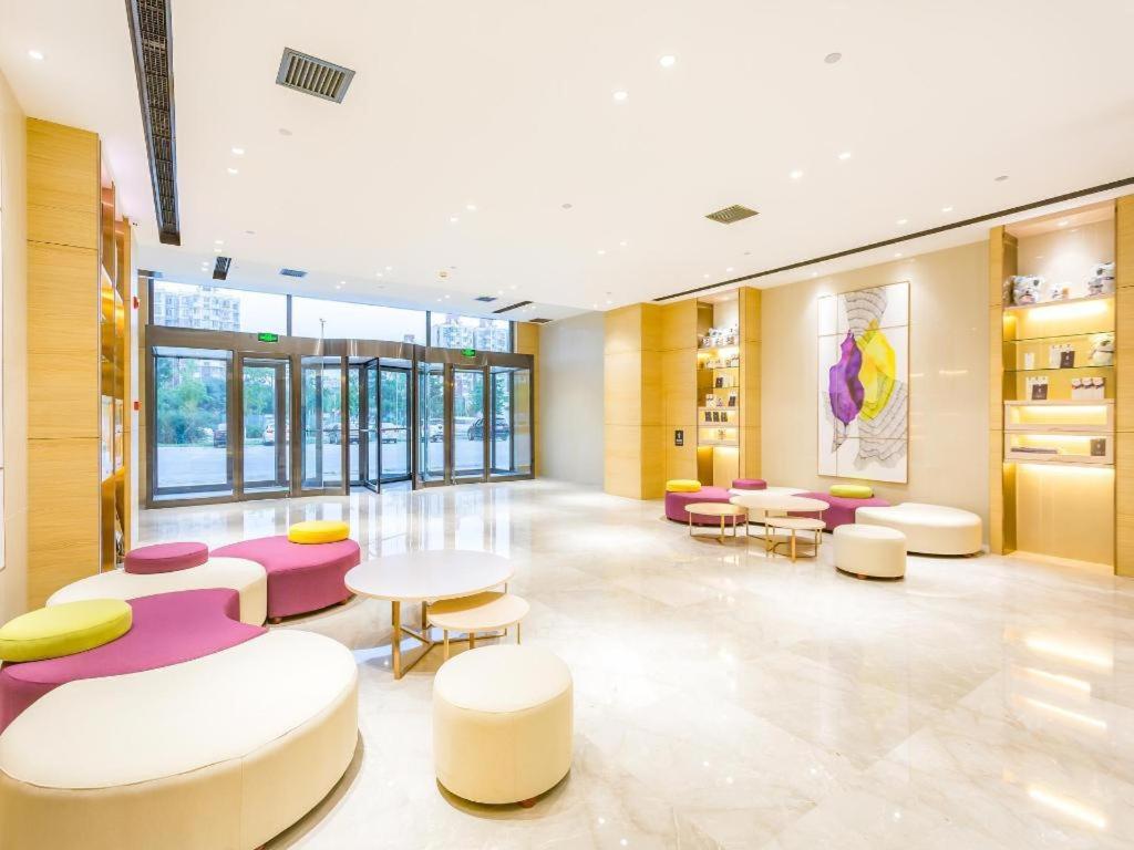 a waiting room with purple and white chairs and tables at Lavande Hotel Beijing Yizhuang Development Zone JD Headquarter in Ciqu