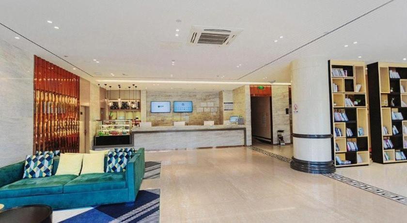 ein Wohnzimmer mit einer blauen Couch in einem Gebäude in der Unterkunft City Comfort Inn Dali High-speed Railway Station Erhai Park in Dali