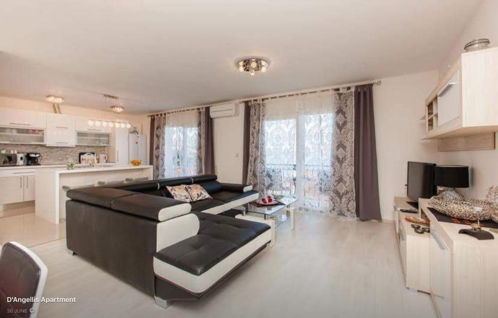 sala de estar amplia con sofá y cocina en D'Angellis Livaja Apartments, en Trogir