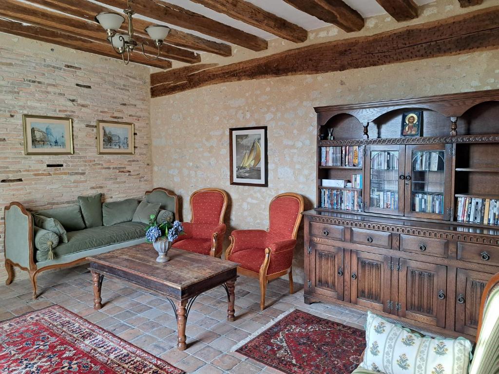 a living room with a couch and a table at Chambres d'Hôtes L'Ecu in Preuilly-sur-Claise