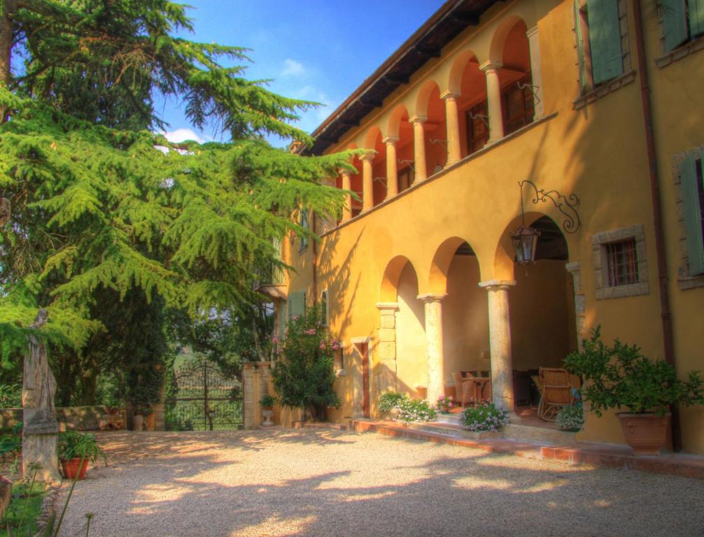 a large yellow building with trees in front of it at Villa Sogara in San Martino Buon Albergo