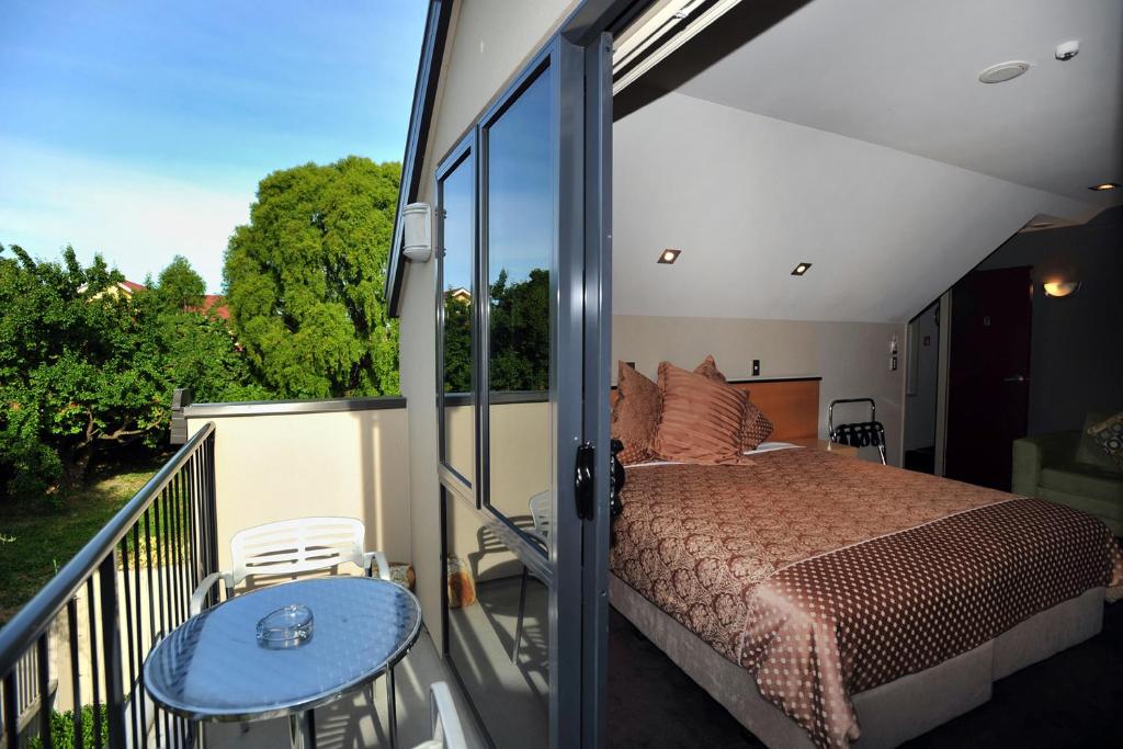 una camera con letto su un balcone di Athena Motel a Christchurch