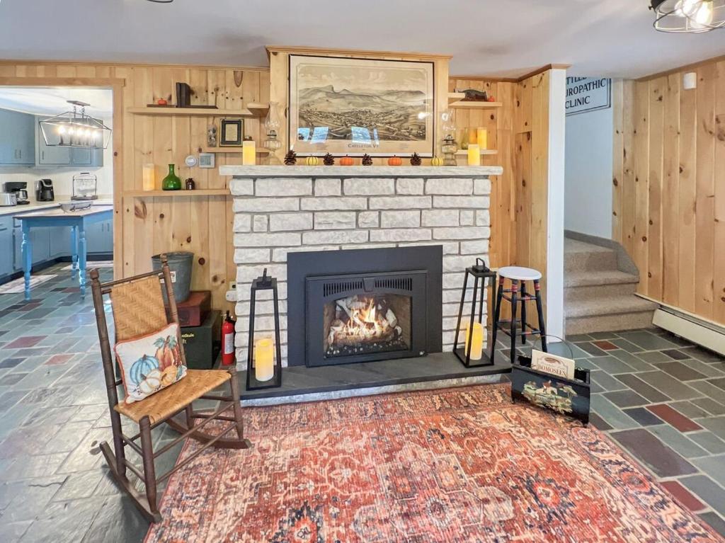 ein Wohnzimmer mit Kamin und Sessel in der Unterkunft The Rosewood home in Bomoseen