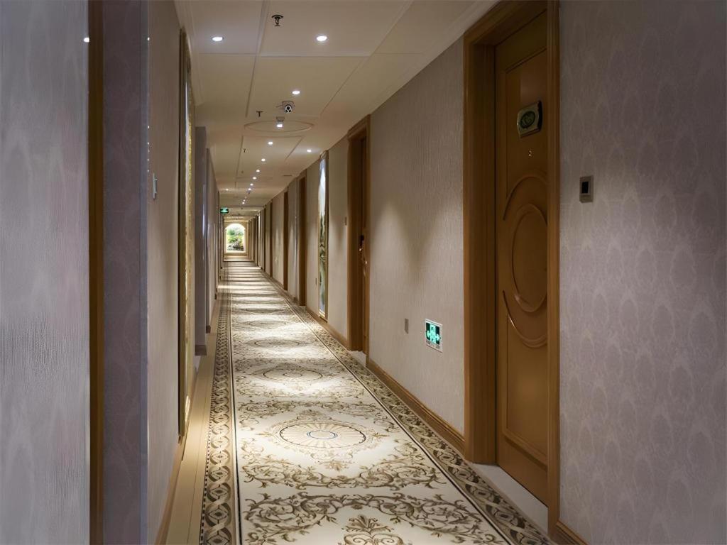 einen Flur mit einem langen Flur mit Fliesenboden in der Unterkunft Vienna Hotel Inner Mongolia Tongliao Development Zone in Tongliao