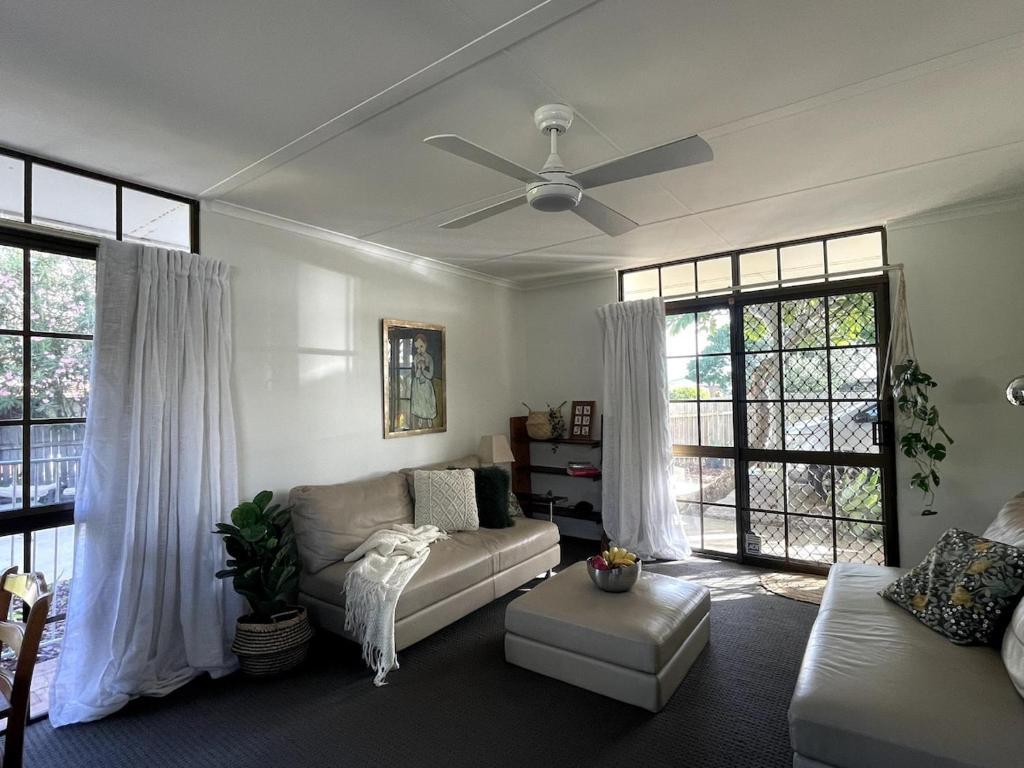 a living room with a couch and a ceiling fan at Corindi Beach Pad in Arrawarra