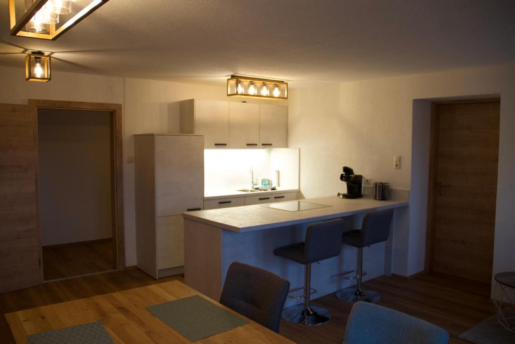 ウルリッヒスベルクにあるFerienwohnung Märzingerのキッチン(カウンター、いくつかの椅子付)