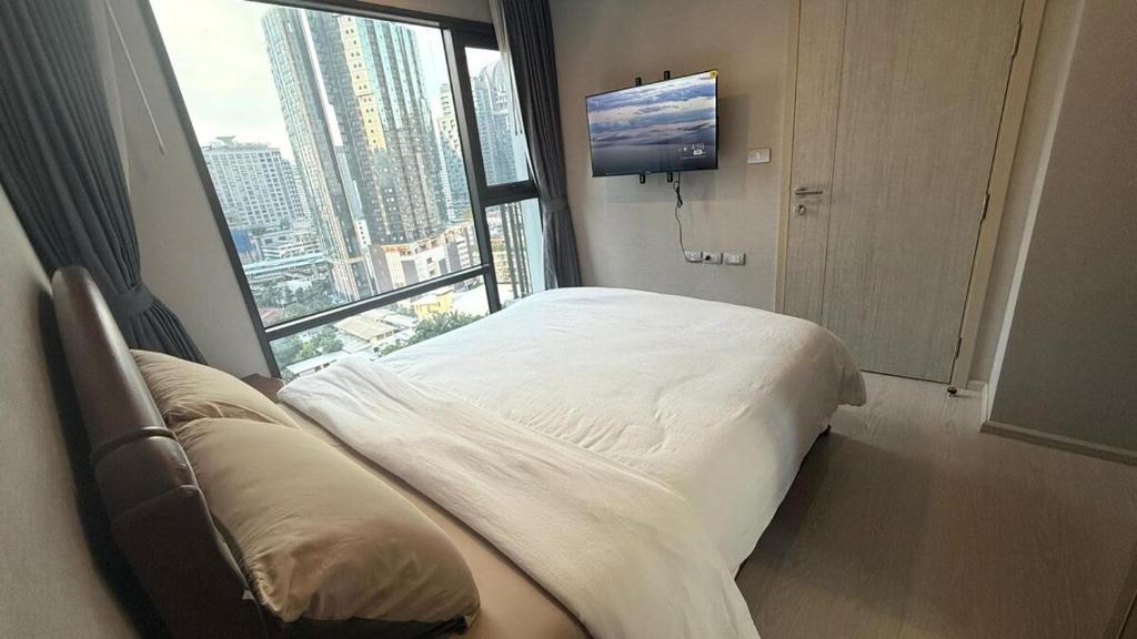 a hotel room with a bed and a large window at Modern Bangkok Apartment Train Access in Bangkok