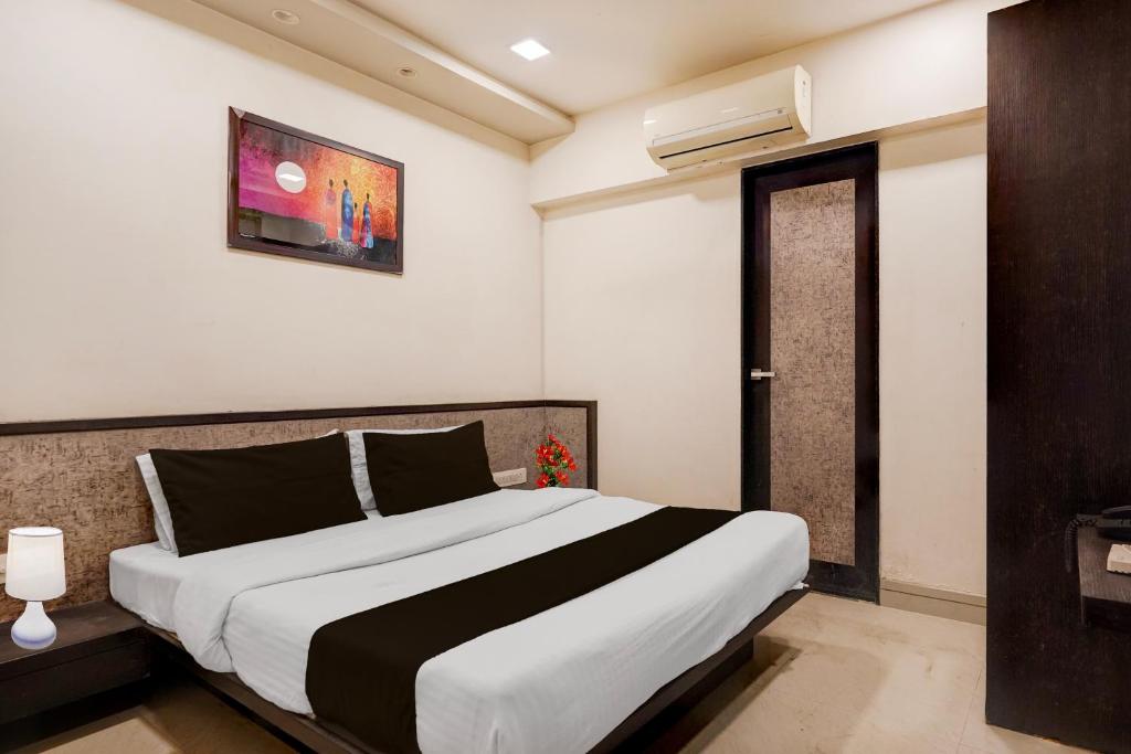 a bedroom with a large bed in a room at Hotel O Vatva Railway Station Formerly Anmol Palace in Ahmedabad