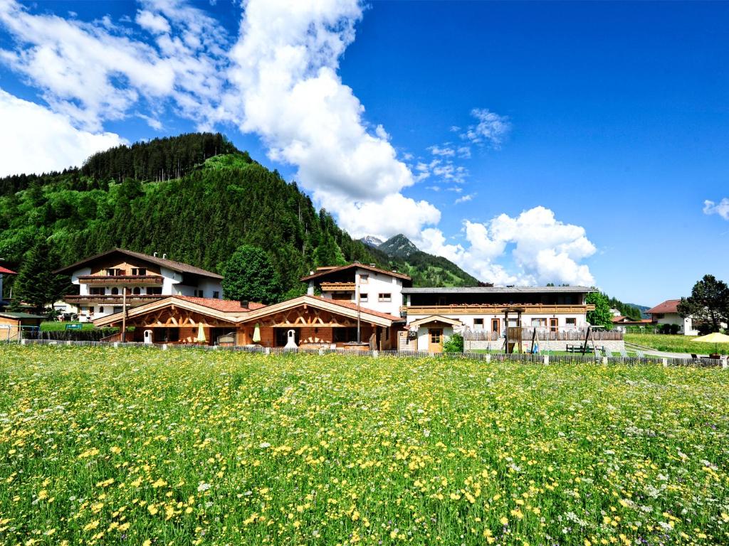 un champ de fleurs devant un bâtiment dans l'établissement Appartements & Chalets Wiesenruh, à Bichlbach