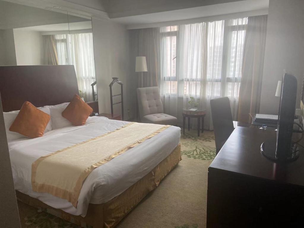 Un dormitorio con una cama, una silla y un escritorio. en Merry Hotel Shanghai (Former Rendezvous Merry Hotel Shanghai), en Shanghái