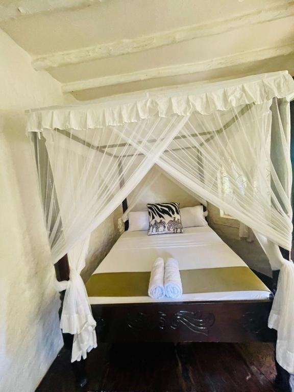 un letto in una camera con baldacchino di 3 bedroom own compound house a Malindi