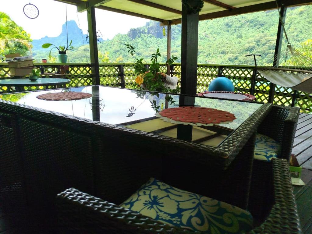 a patio with a table and chairs on a porch at Haut de Baie de Cook Moorea 6 nuits minimum in Paopao